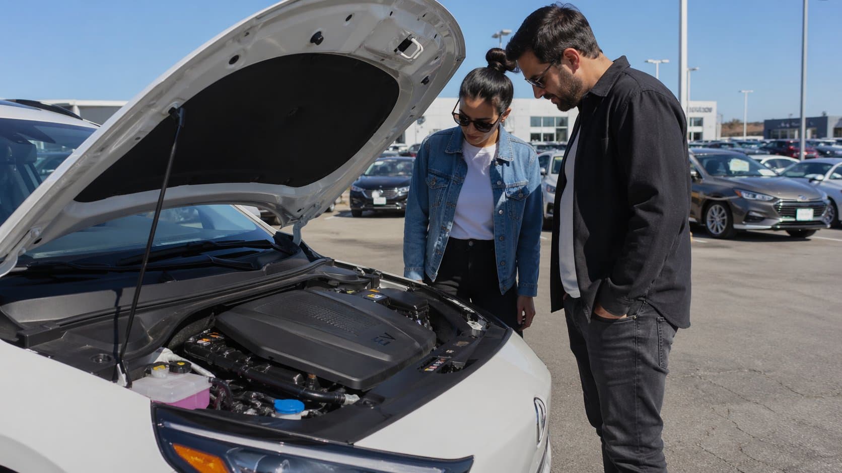 Couple inspecting a used EV at a dealership